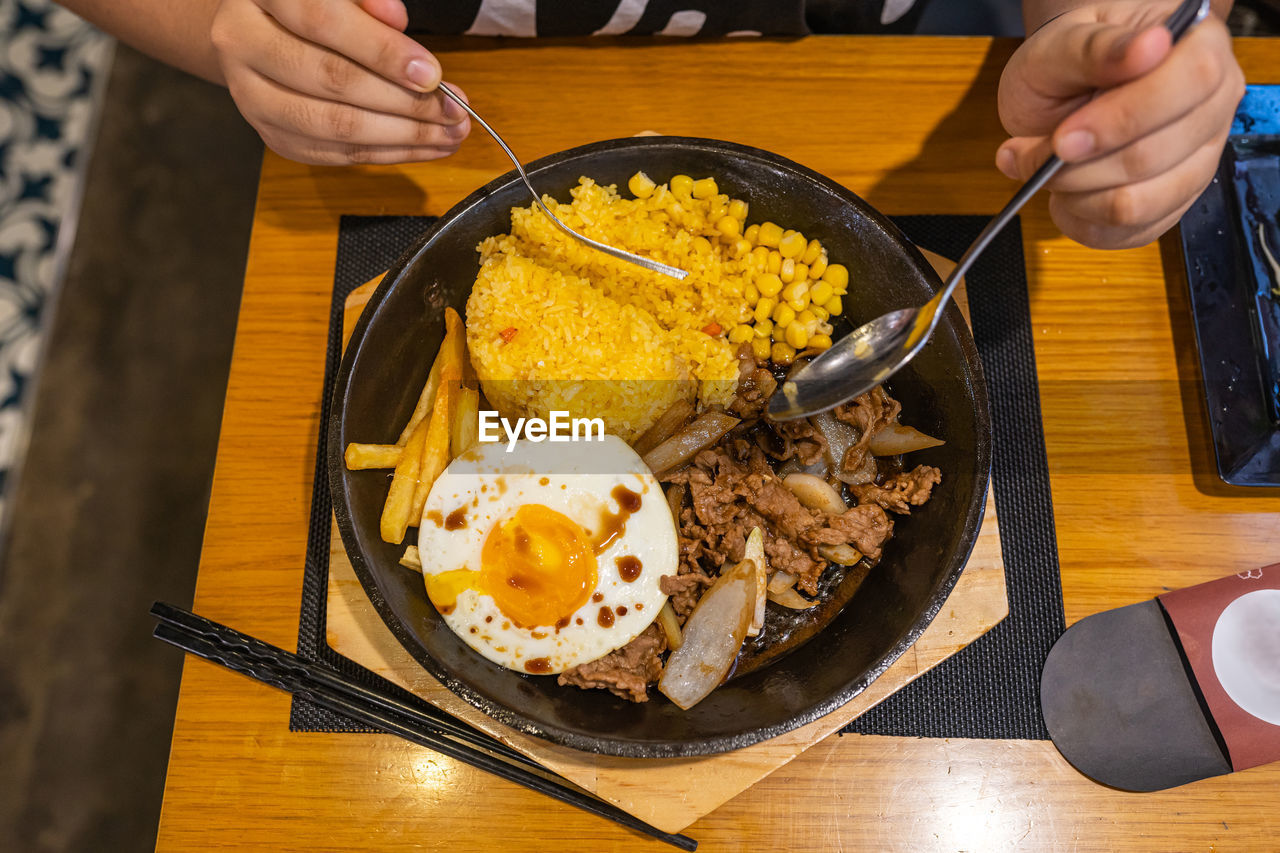 MIDSECTION OF MAN HOLDING FOOD