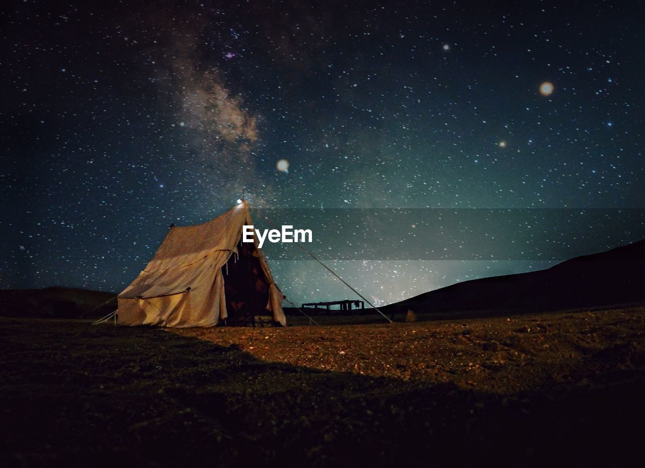 Tent on field against sky at night