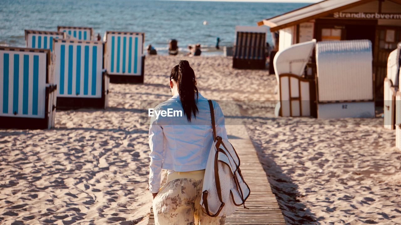 Rear view of woman walking at beach