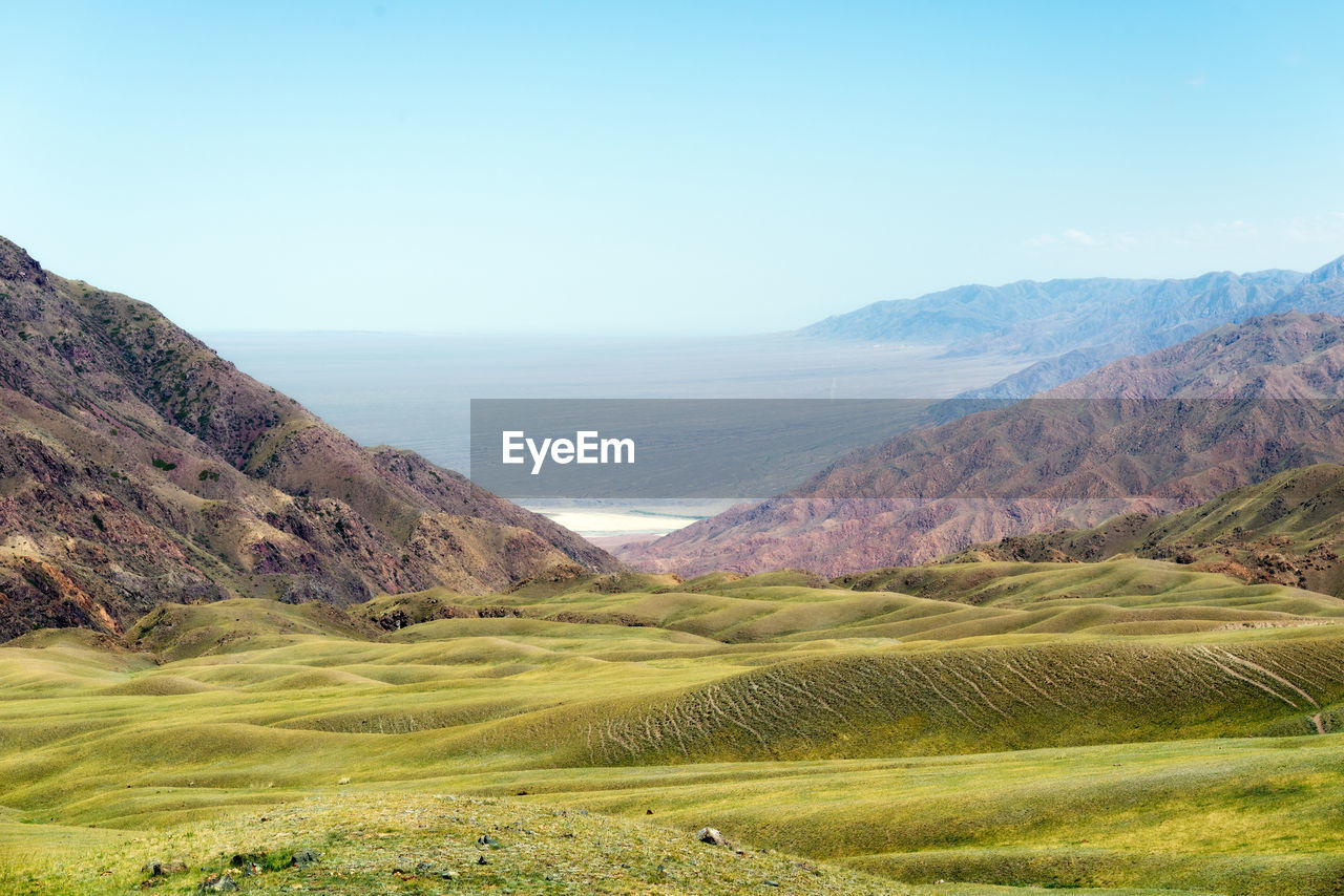 Scenic view of landscape and mountains against clear sky