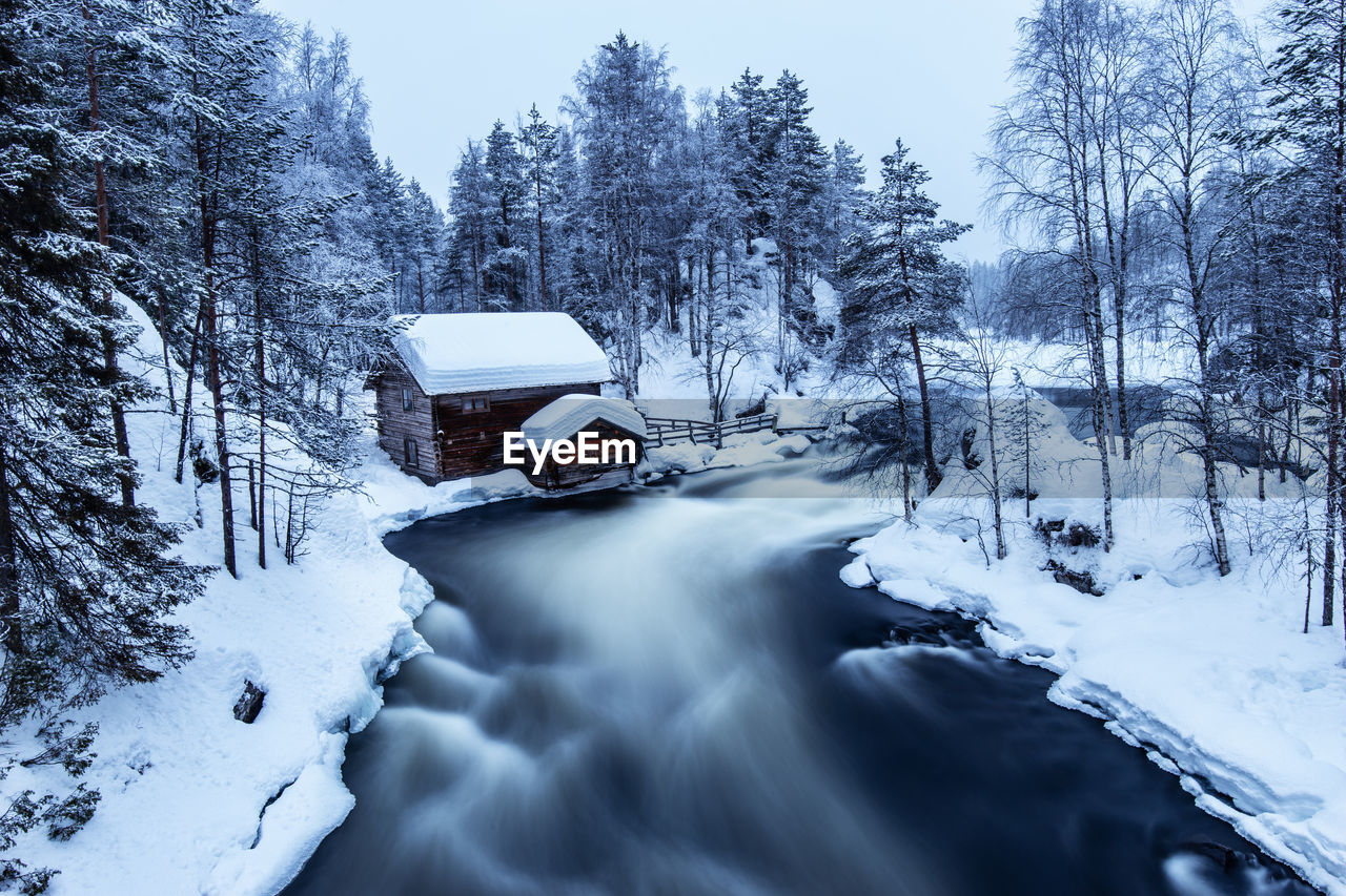 Blurred motion of river in snow covered forest