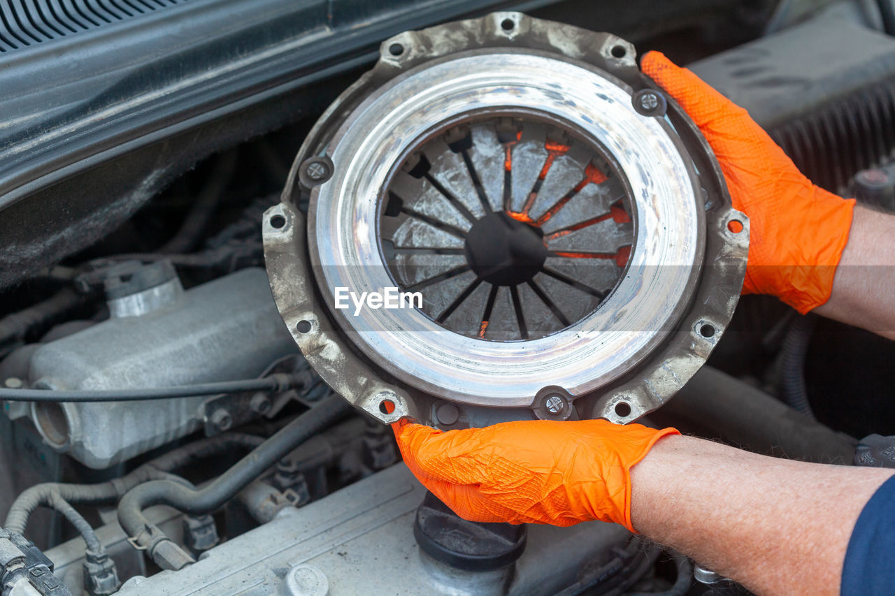 Close-up of hand holding orange wheel