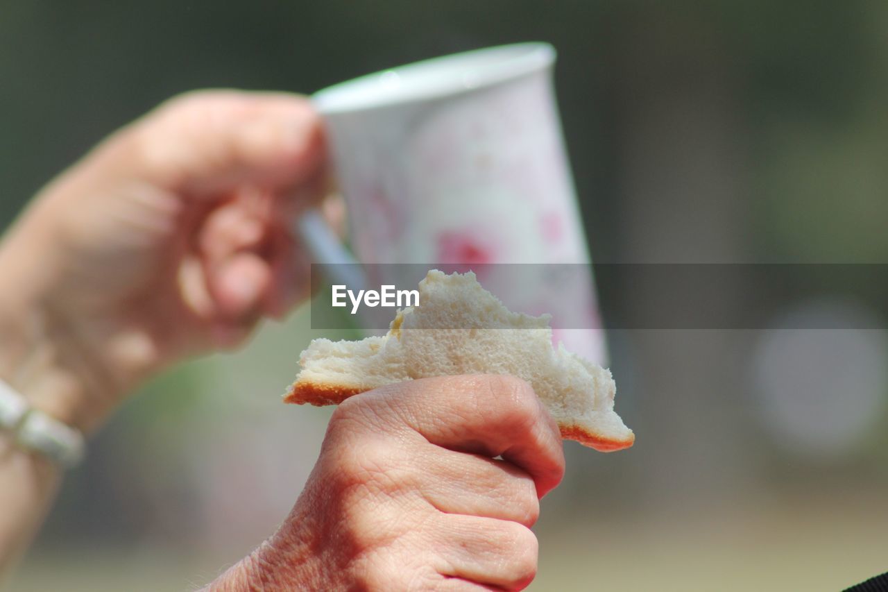 CLOSE-UP OF HAND HOLDING ICE CREAM CONE