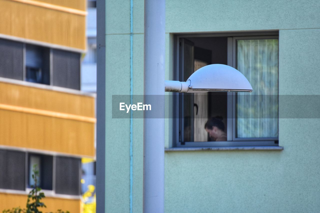 REAR VIEW OF MAN WALKING ON BUILDING