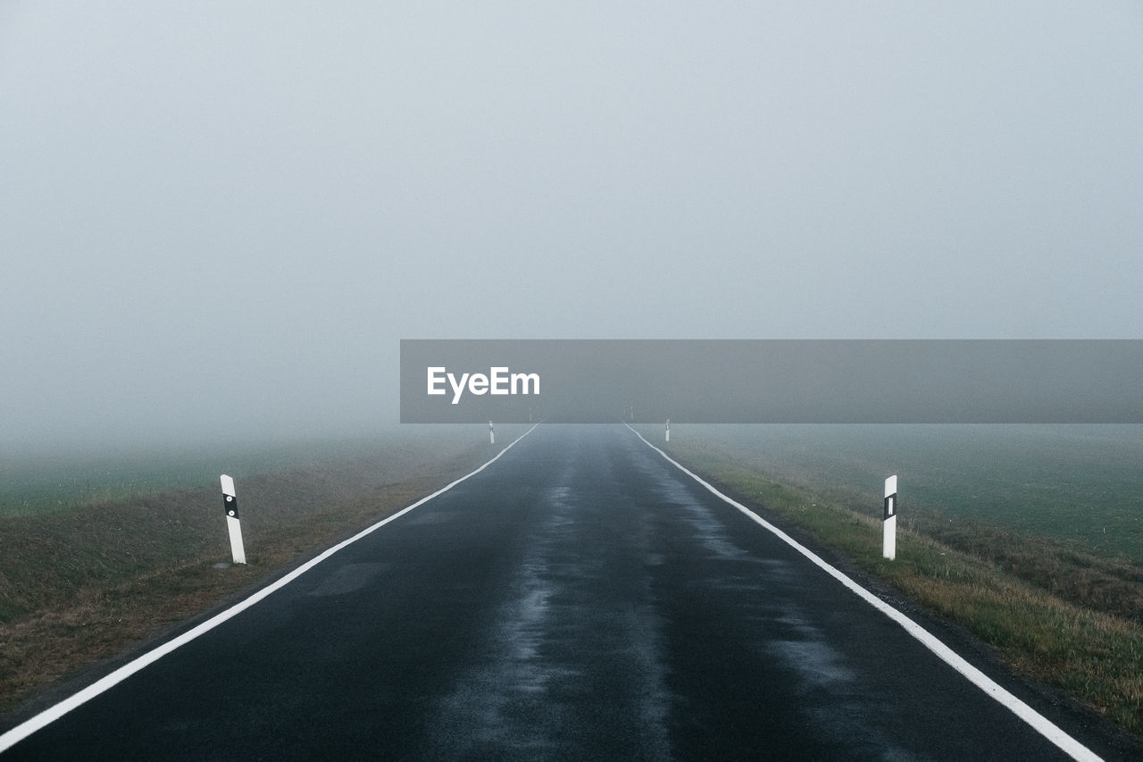 Road amidst foggy weather against sky