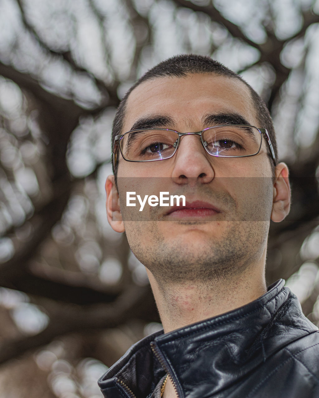 CLOSE-UP PORTRAIT OF YOUNG MAN WEARING EYEGLASSES