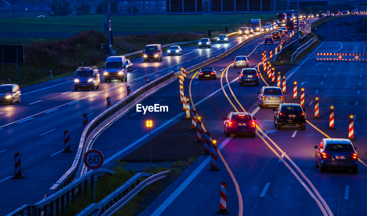 Vehicle traffic on a highway at night, in a construction site area