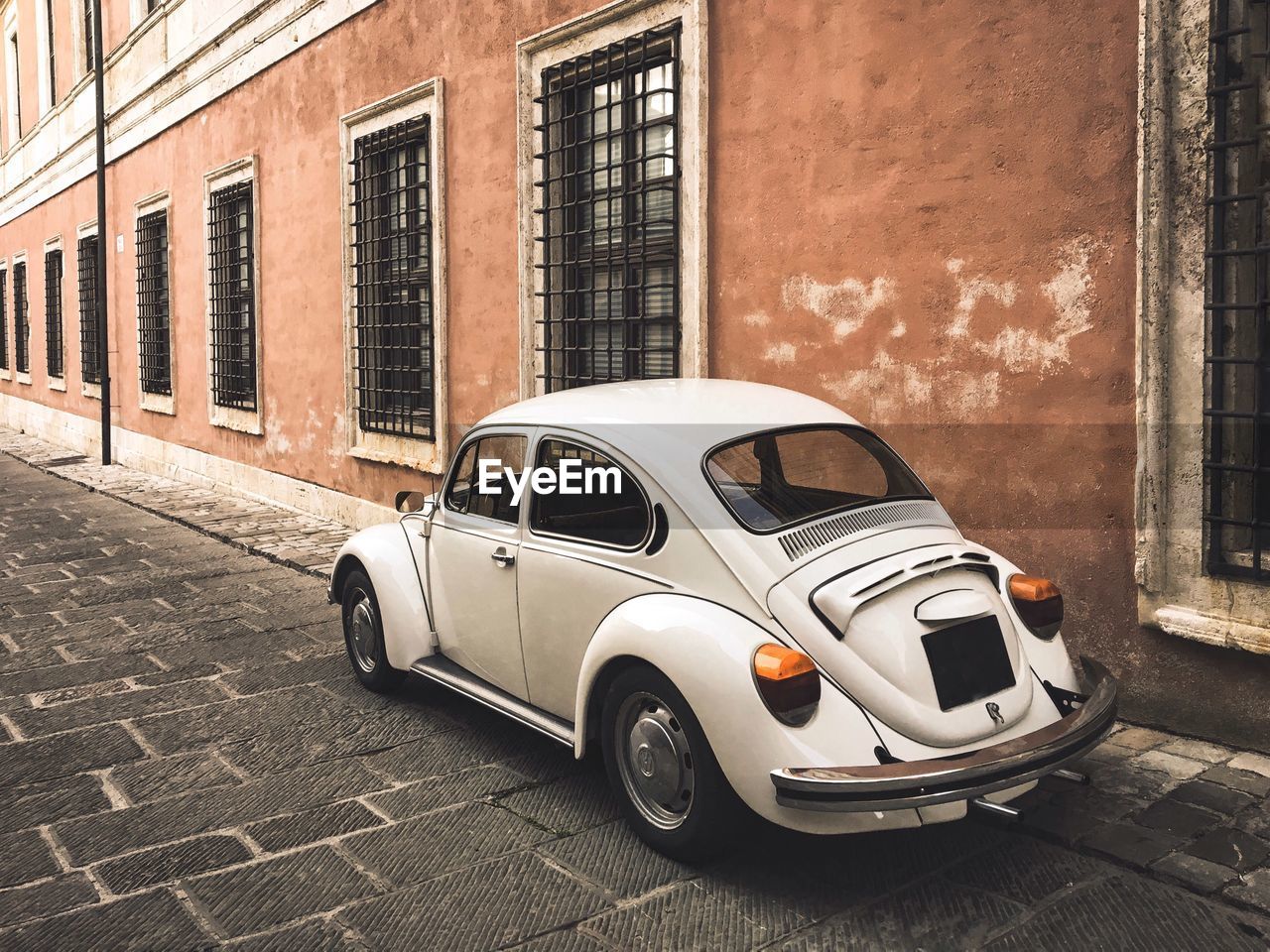 VINTAGE CAR ON STREET BY BUILDINGS