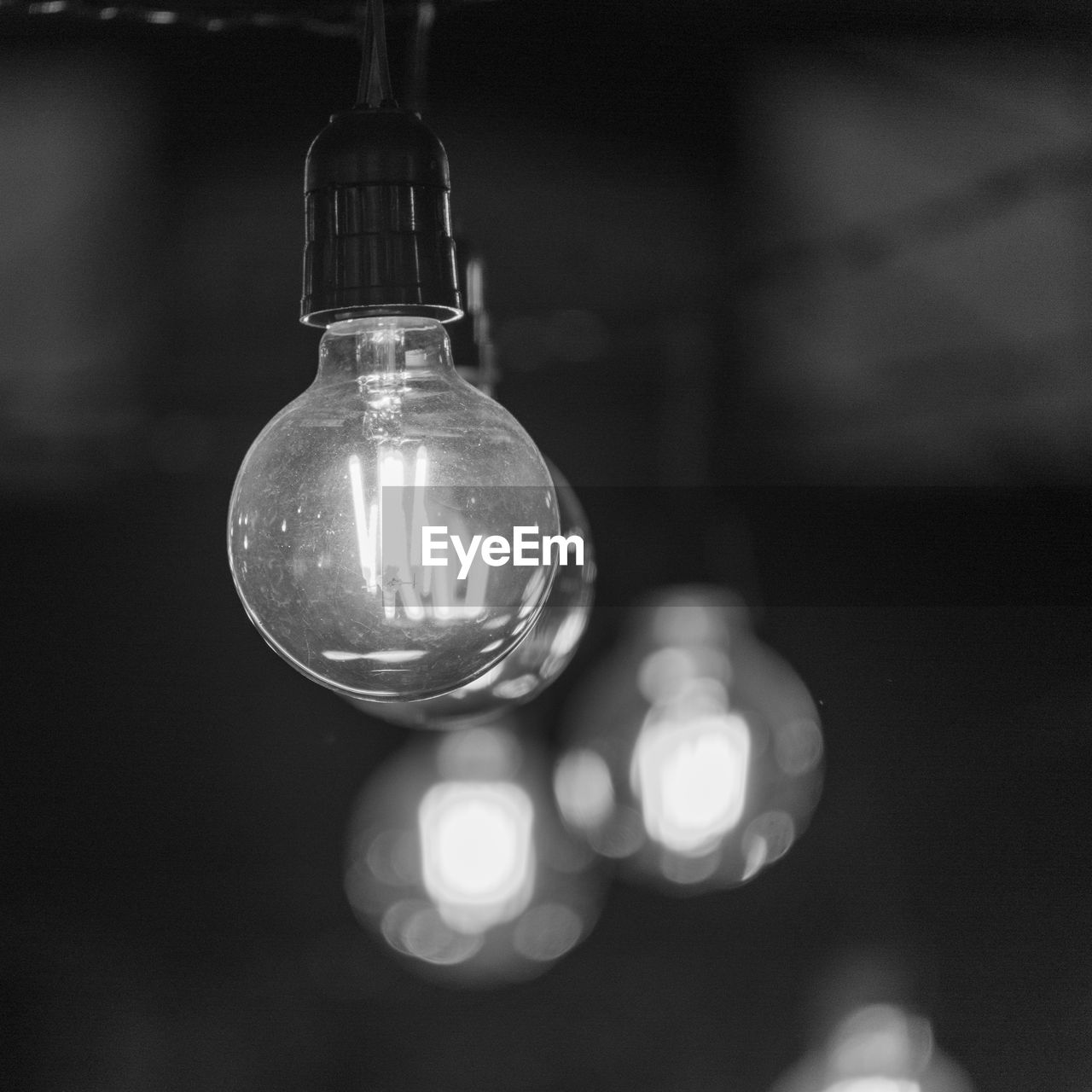 white, light bulb, lighting equipment, electricity, black, darkness, filament, black and white, incandescent light bulb, hanging, close-up, illuminated, light, focus on foreground, indoors, no people, macro photography, glass, electric light, monochrome photography, single object, glowing, lighting, light - natural phenomenon, still life photography, monochrome, light fixture