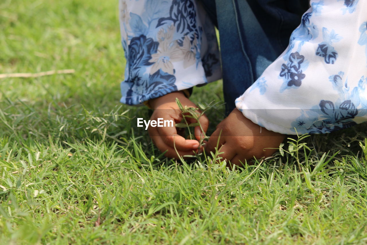 LOW SECTION OF WOMAN WEARING SHOES ON FIELD