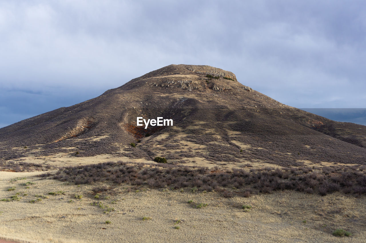 Low angle view of mountain against cloudy sky