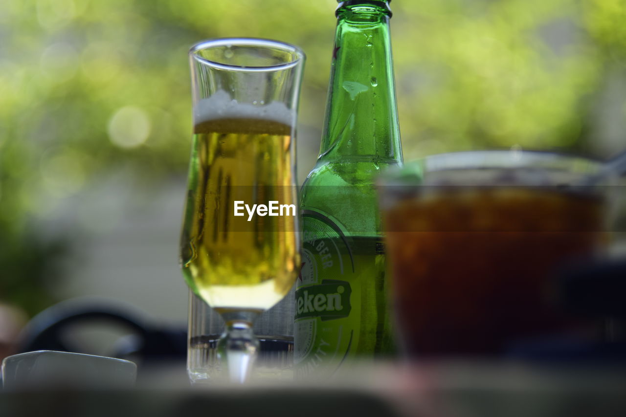 CLOSE-UP OF BEER GLASS ON TABLE