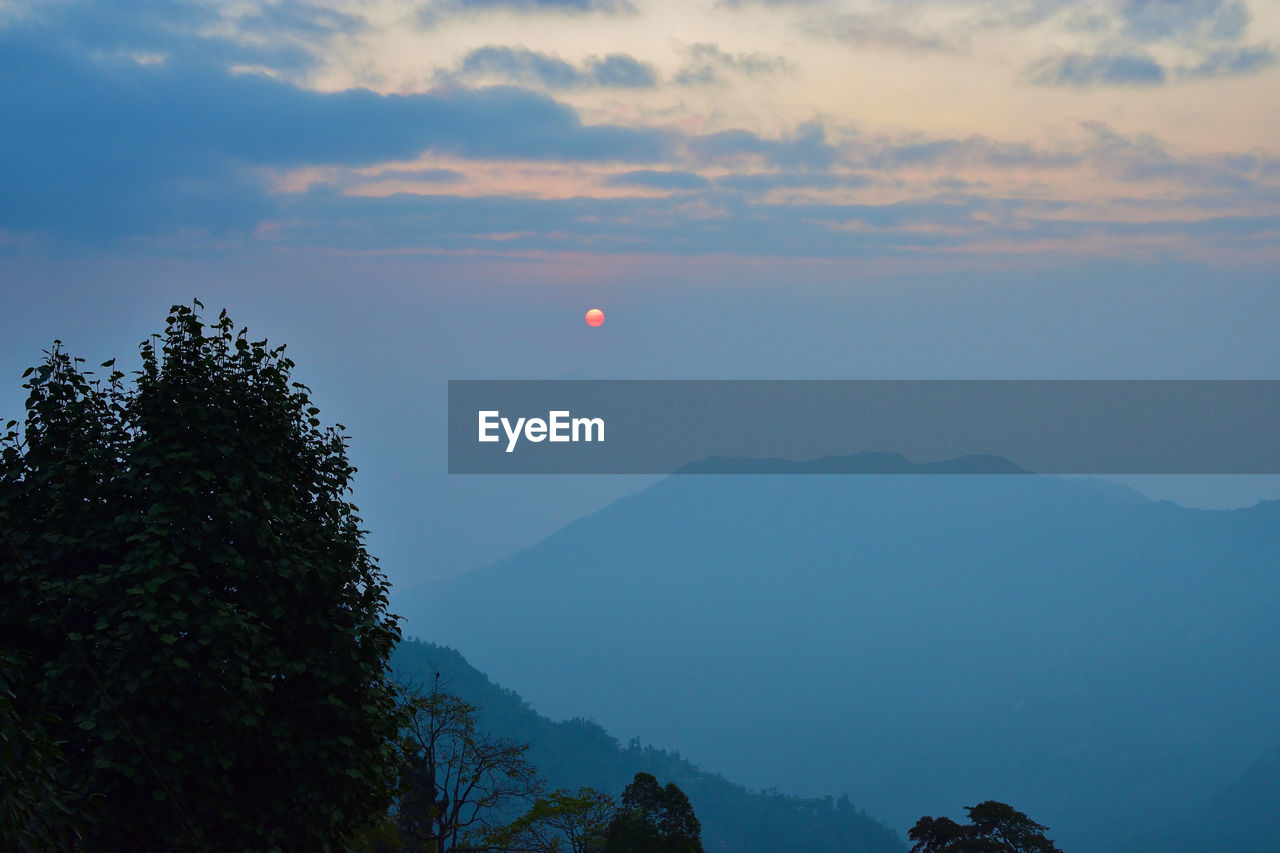 Scenic view of silhouette mountains against sky at sunrise or sunset.