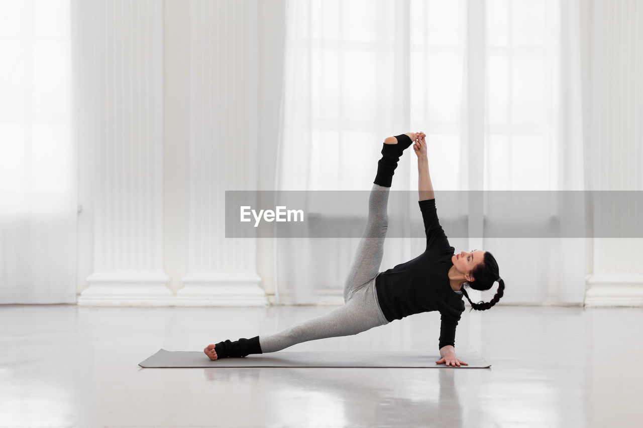 side view of woman exercising in gym