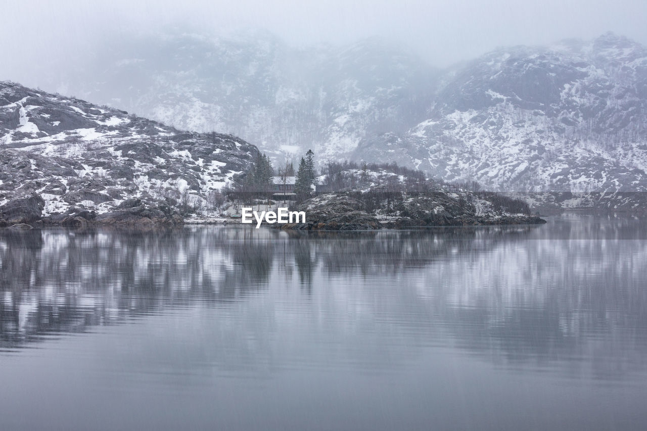 Scenic view of lake by snowcapped mountains during winter