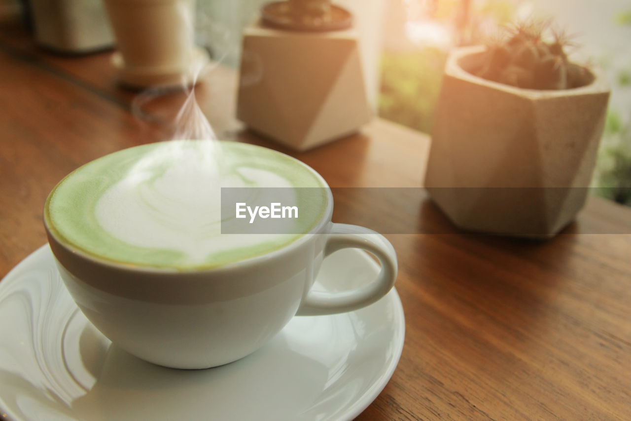 CLOSE-UP OF COFFEE CUP AND TEA ON TABLE