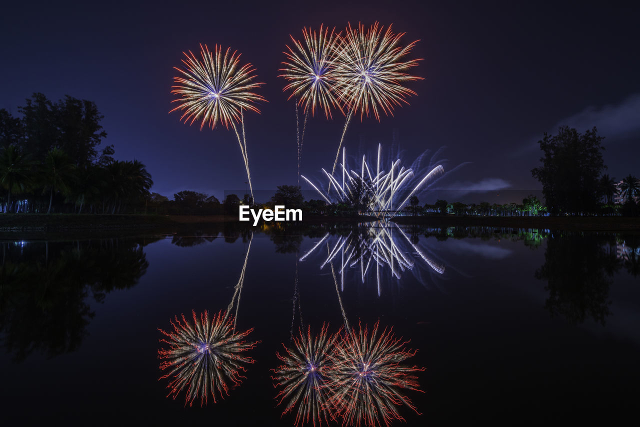 Firework display over lake at night