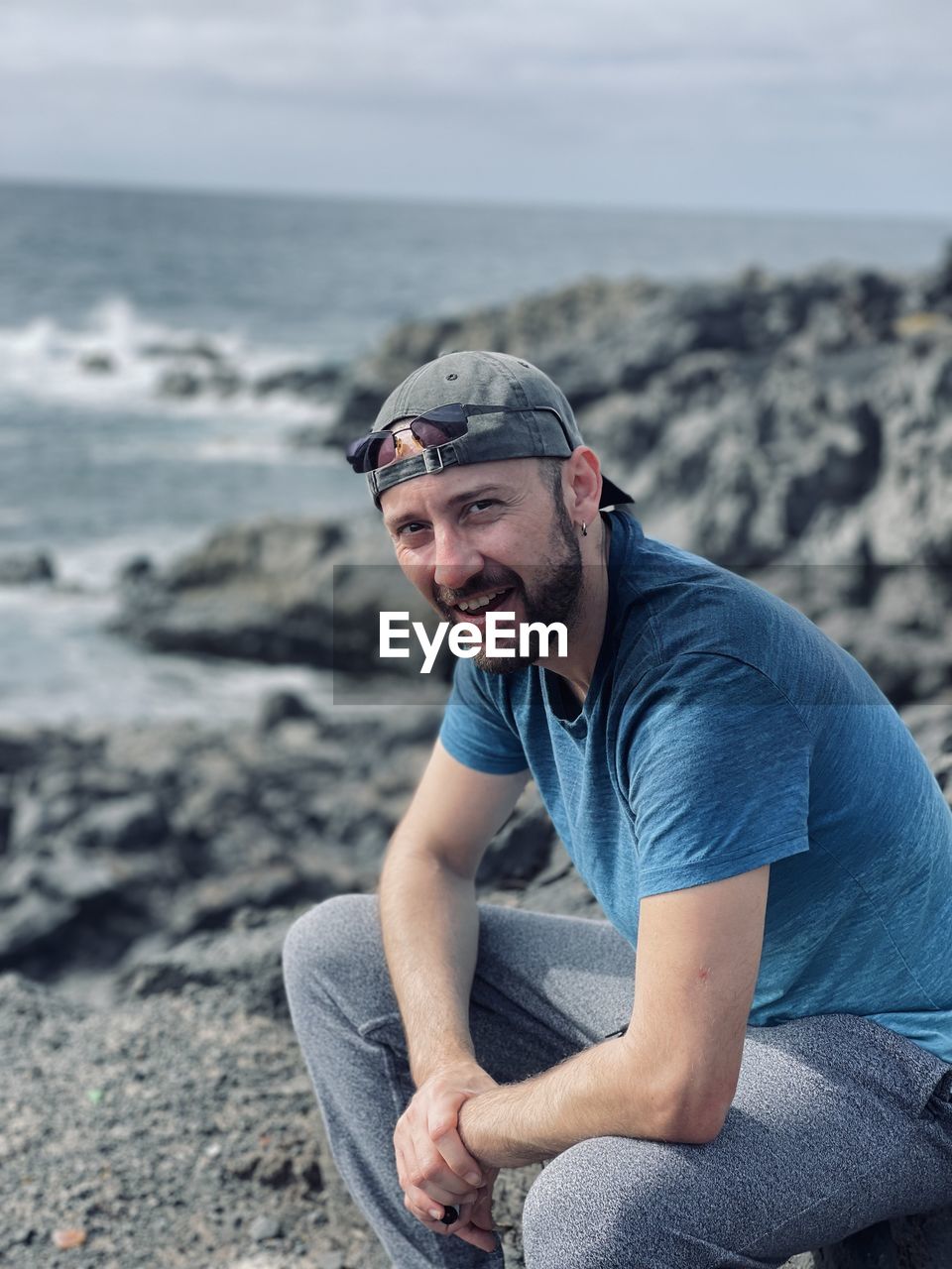 Portrait of young man sitting at beach