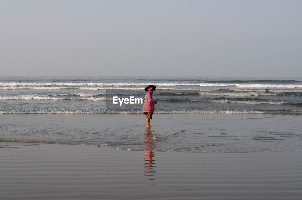 Man standing on beach against sky