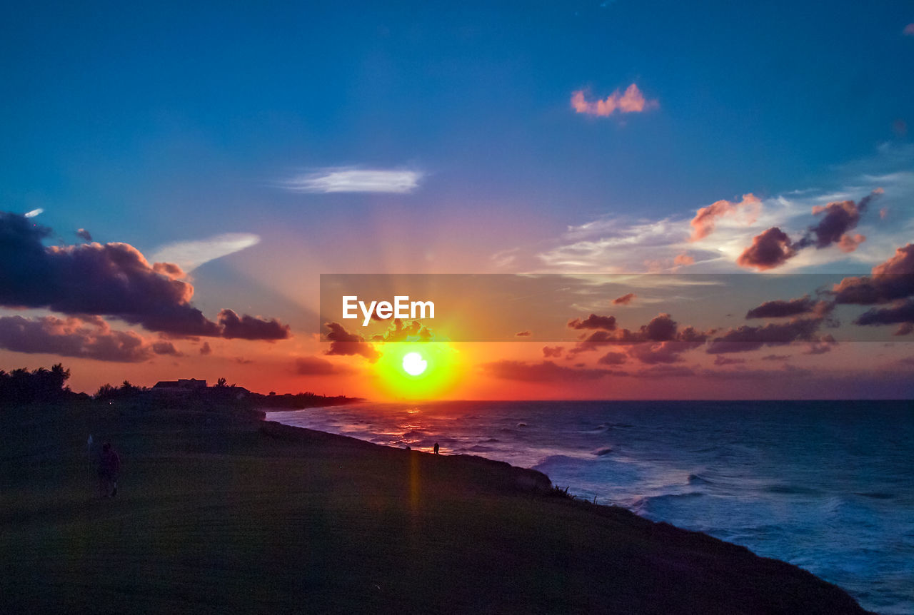 SCENIC VIEW OF BEACH AGAINST SKY AT SUNSET