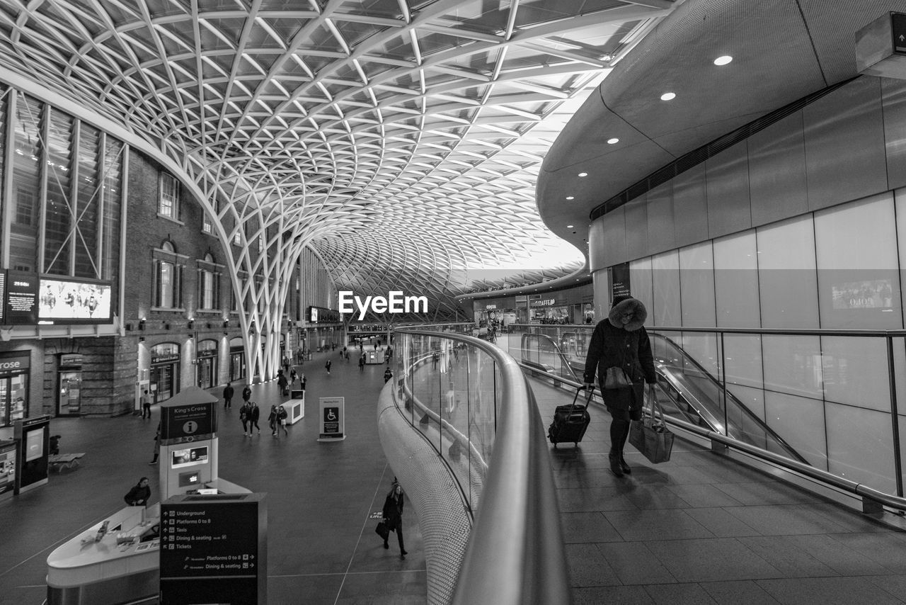 PEOPLE WALKING IN ILLUMINATED MODERN AIRPORT