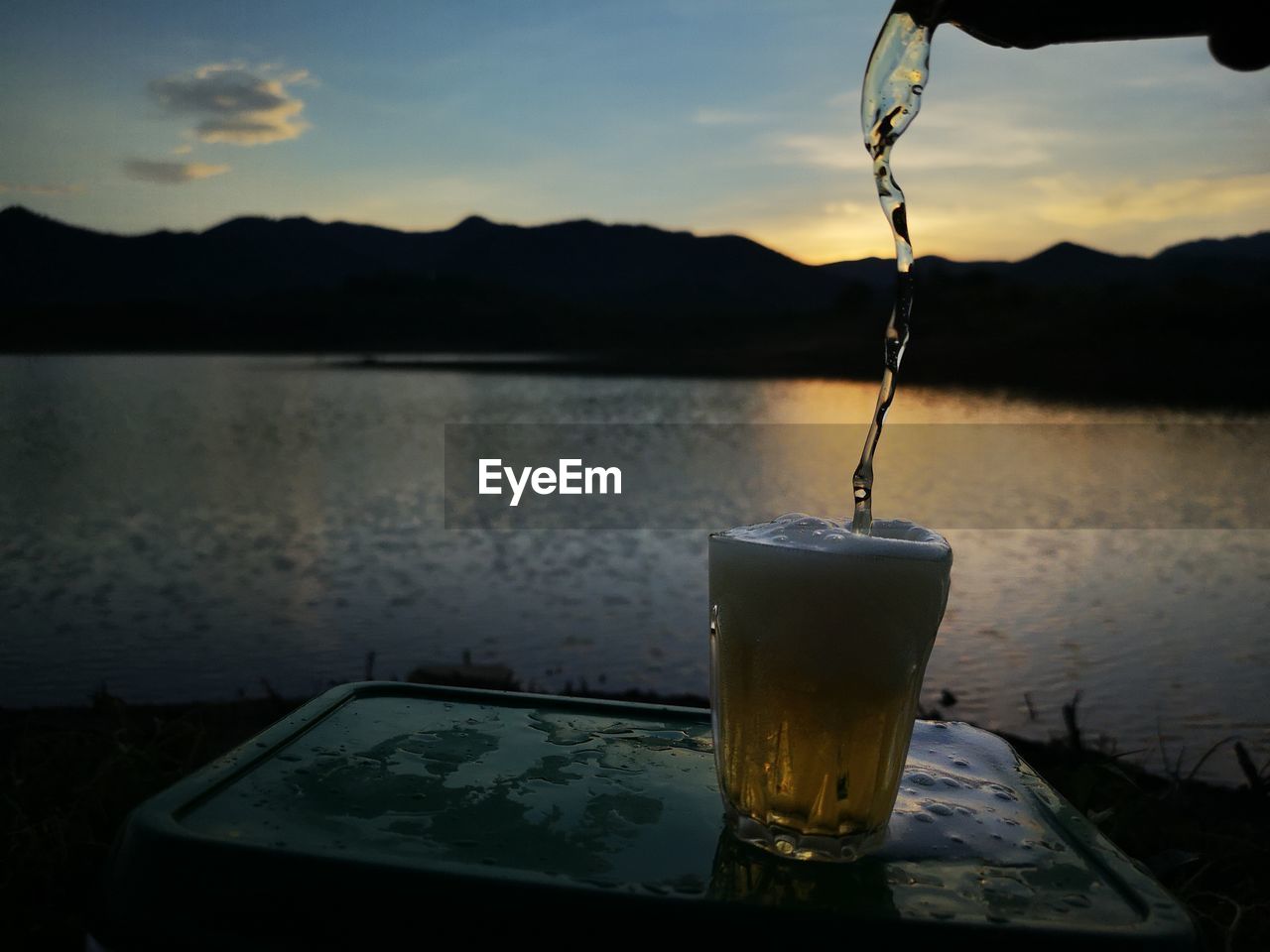 water, reflection, food and drink, drink, morning, sky, refreshment, nature, mountain, household equipment, drinking glass, lake, glass, no people, cloud, light, alcohol, darkness, outdoors, lighting, freshness, food, focus on foreground, dusk