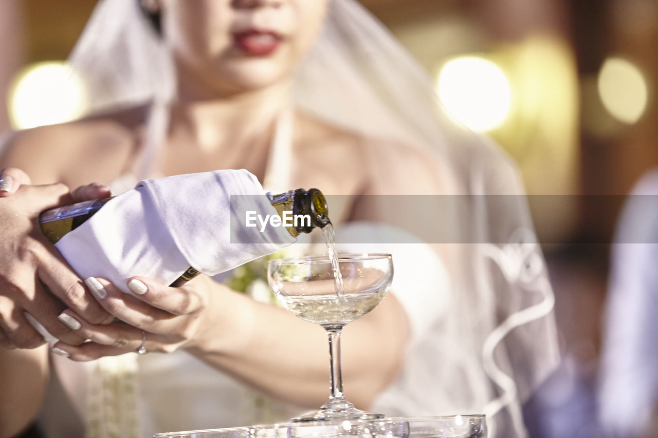 Close-up of bride pouring champagne