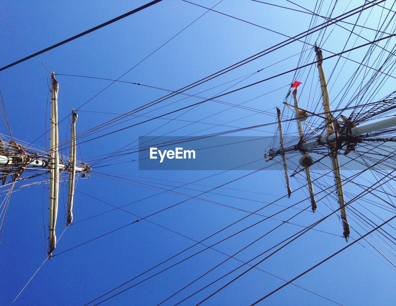 LOW ANGLE VIEW OF POWER LINES AGAINST BLUE SKY