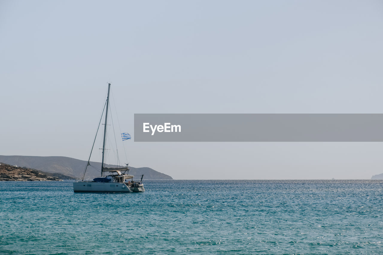 SAILBOATS SAILING ON SEA AGAINST CLEAR SKY