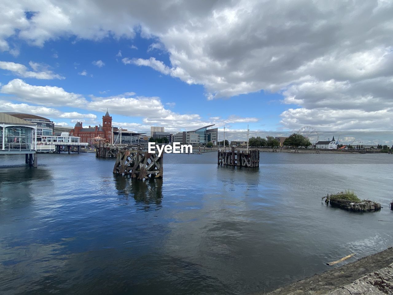 BUILDINGS BY RIVER AGAINST SKY