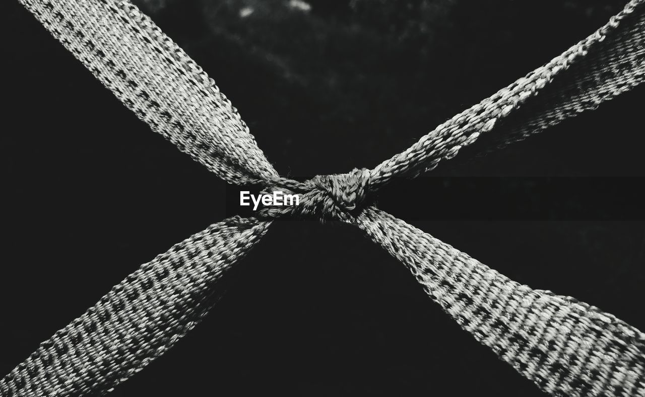 Close-up of rope tied up against black background