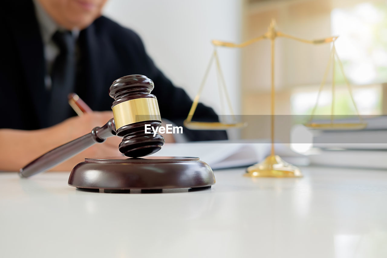 Midsection of lawyer with gavel at table