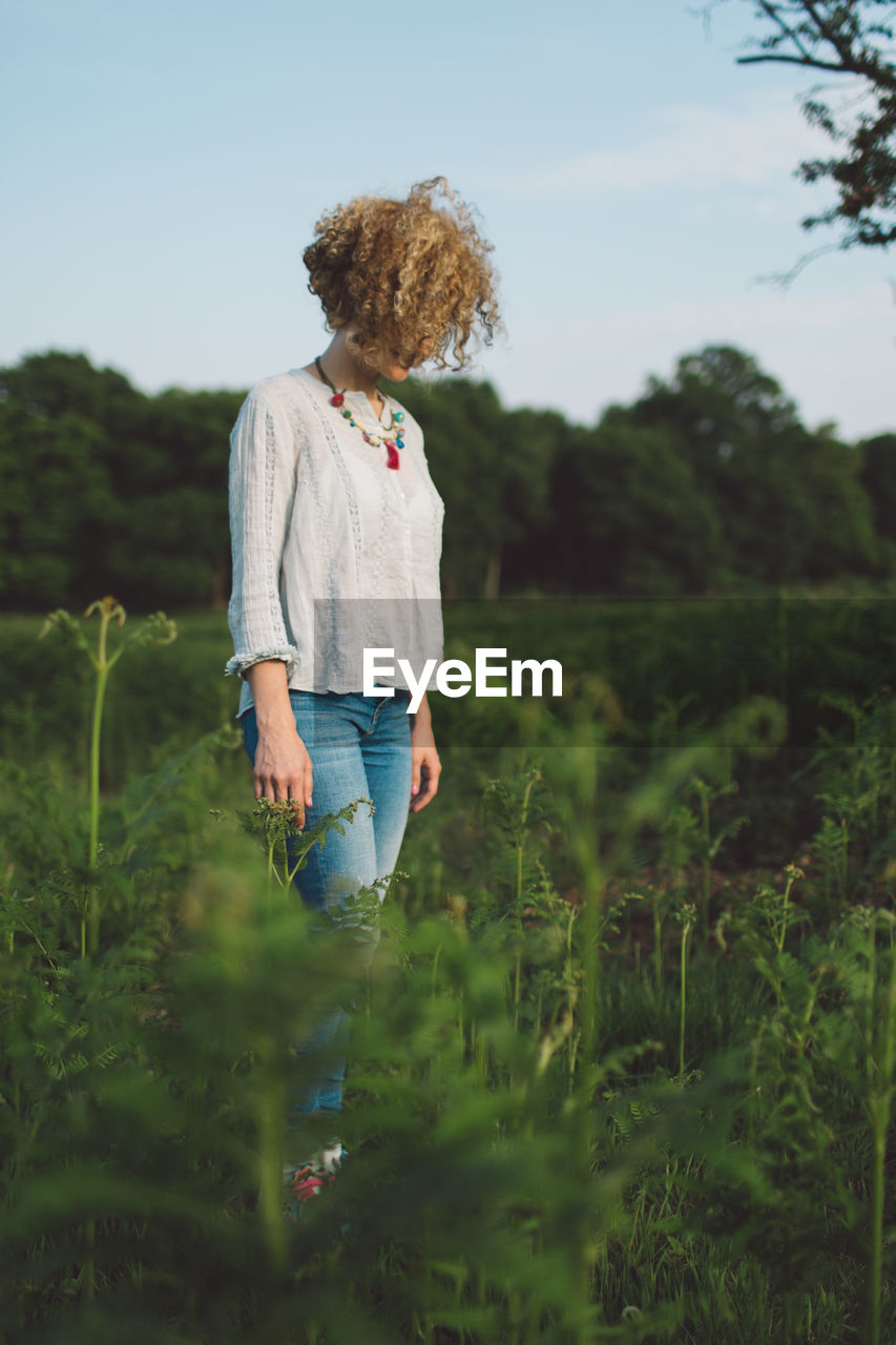 Woman standing on field against sky