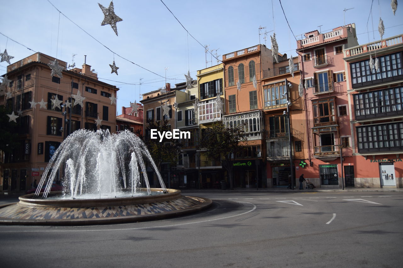 FOUNTAIN BY BUILDING AGAINST SKY