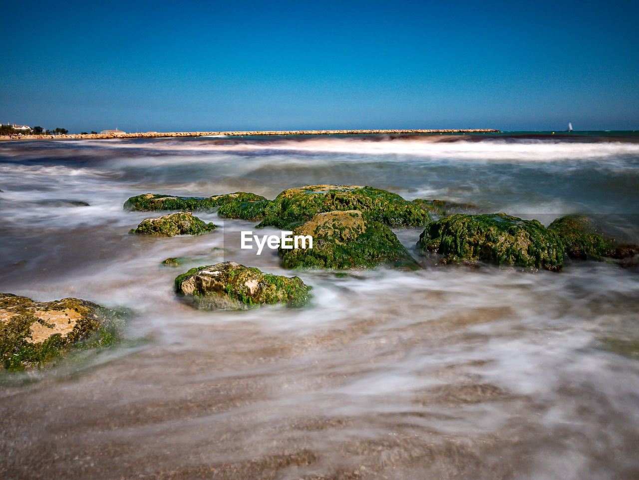 Scenic view of sea against clear blue sky