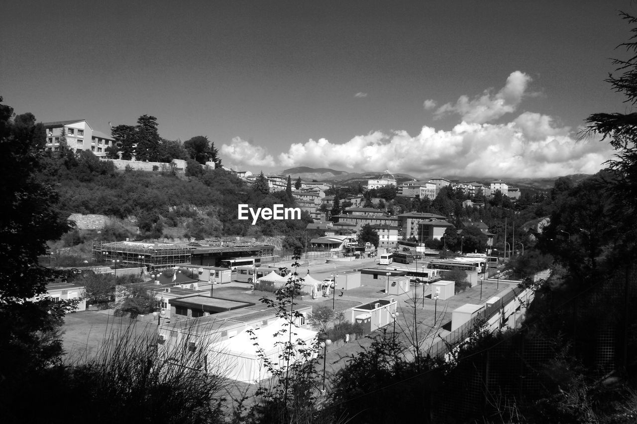 HIGH ANGLE VIEW OF BUILT STRUCTURES AGAINST TREES