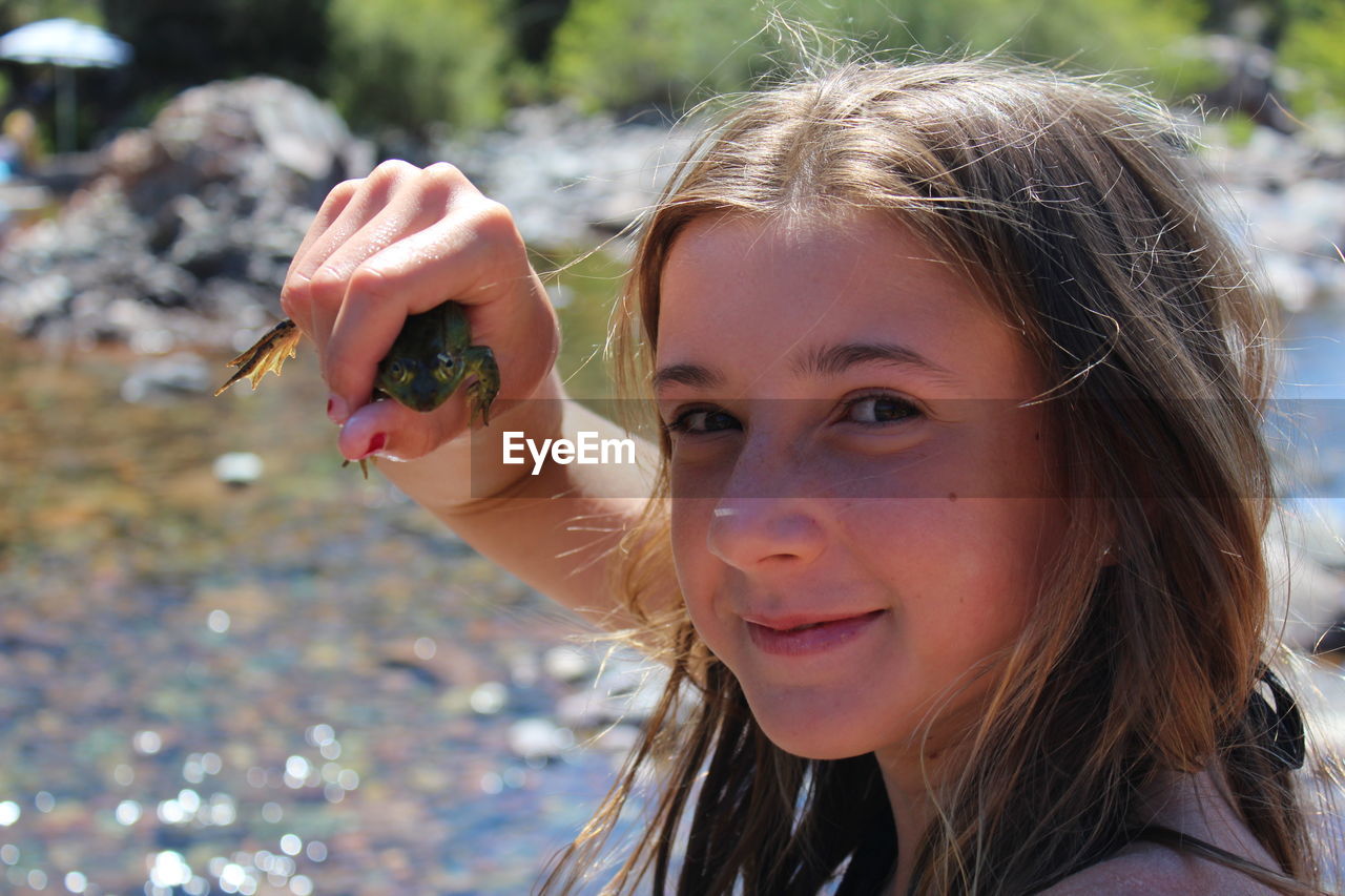 Close-up portrait of girl holding frog