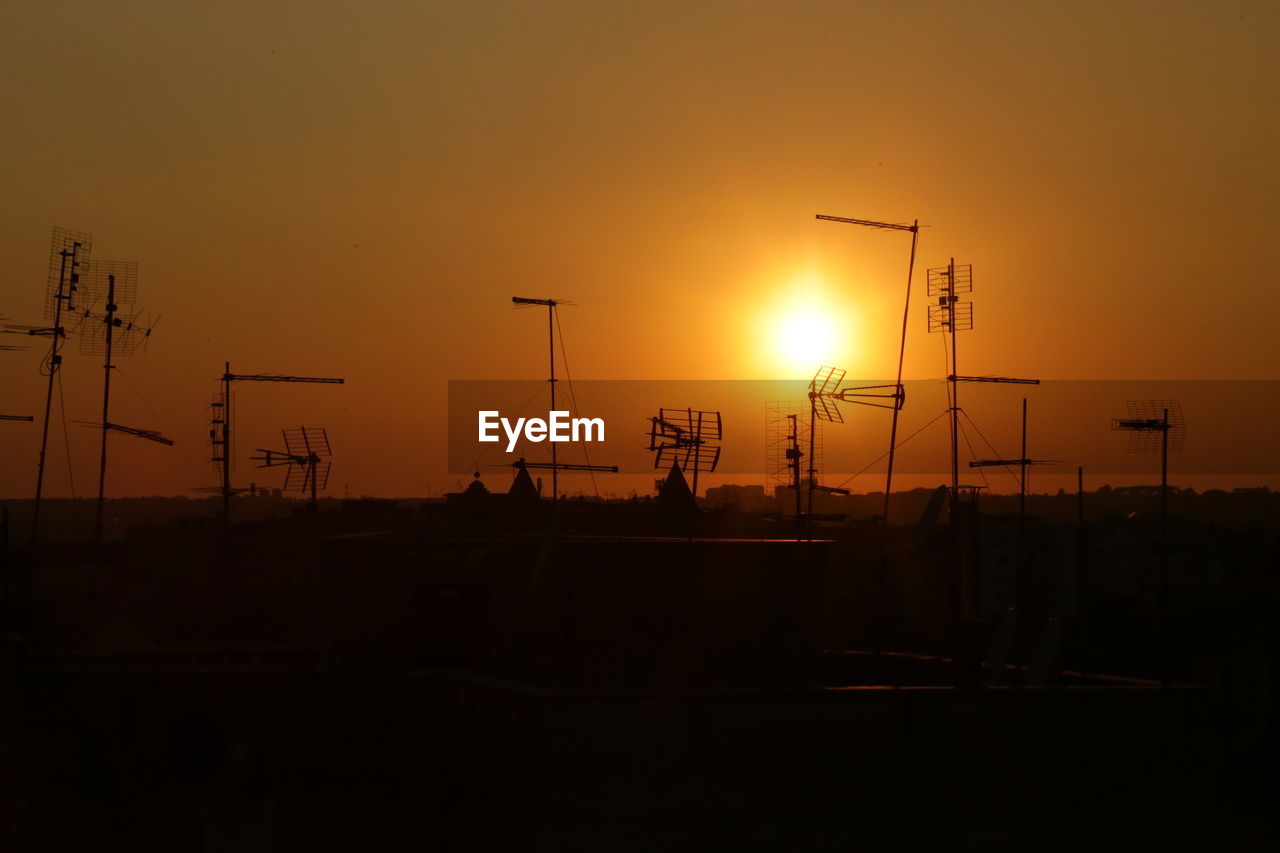 SILHOUETTE CRANES AGAINST ORANGE SKY