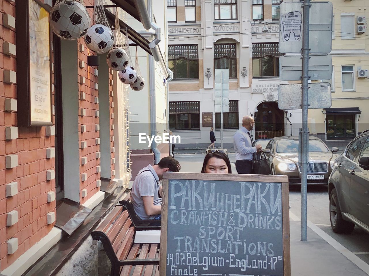 PEOPLE SITTING IN FRONT OF BUILDINGS