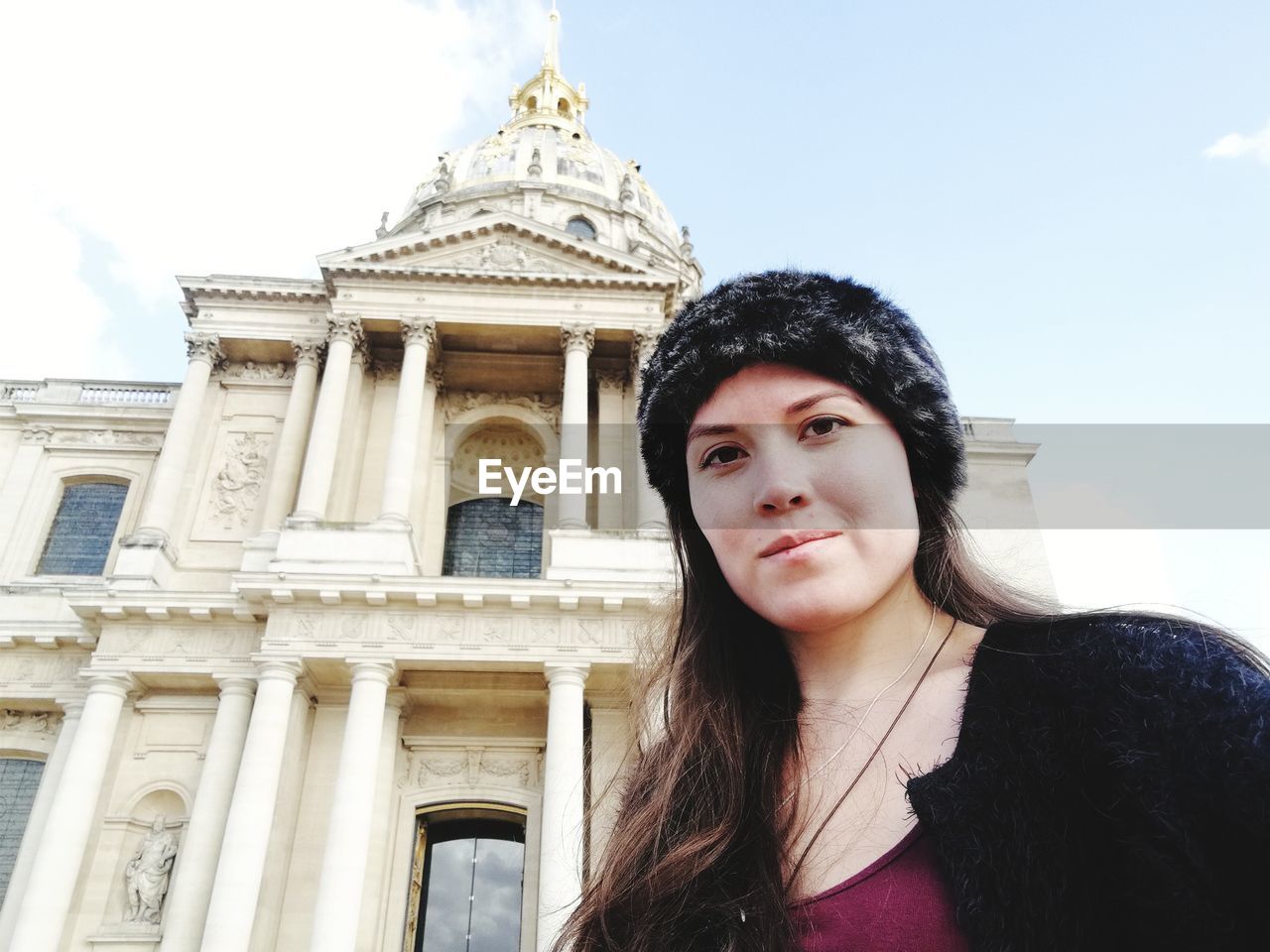 Low angle portrait of woman standing against sky