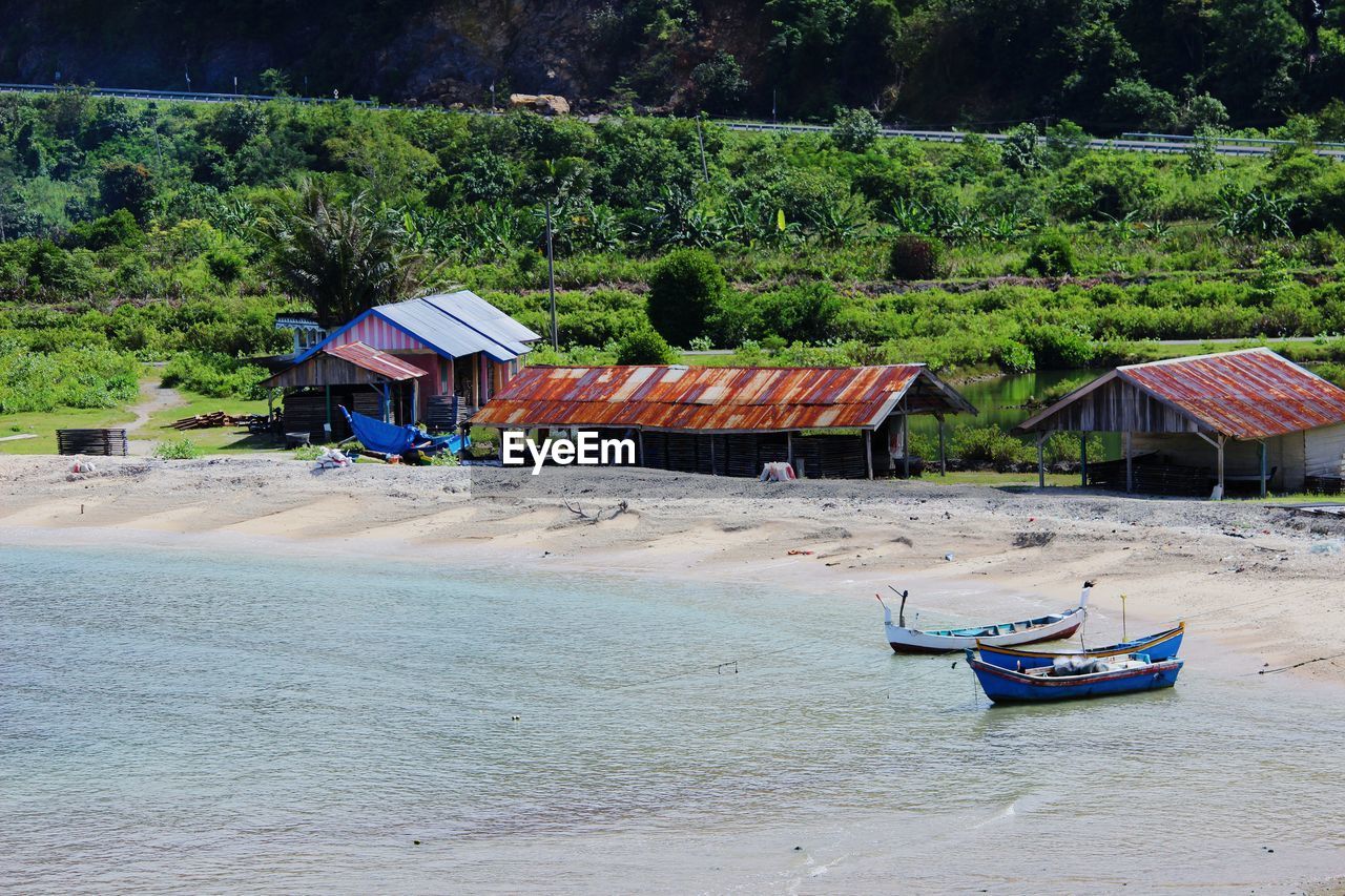 Boat moored at beach against sky