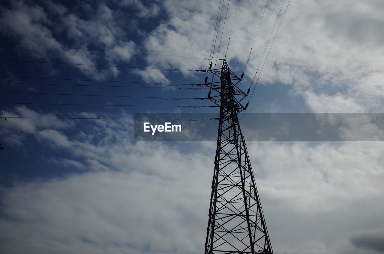 Low angle view of silhouette electricity pylon against cloudy sky