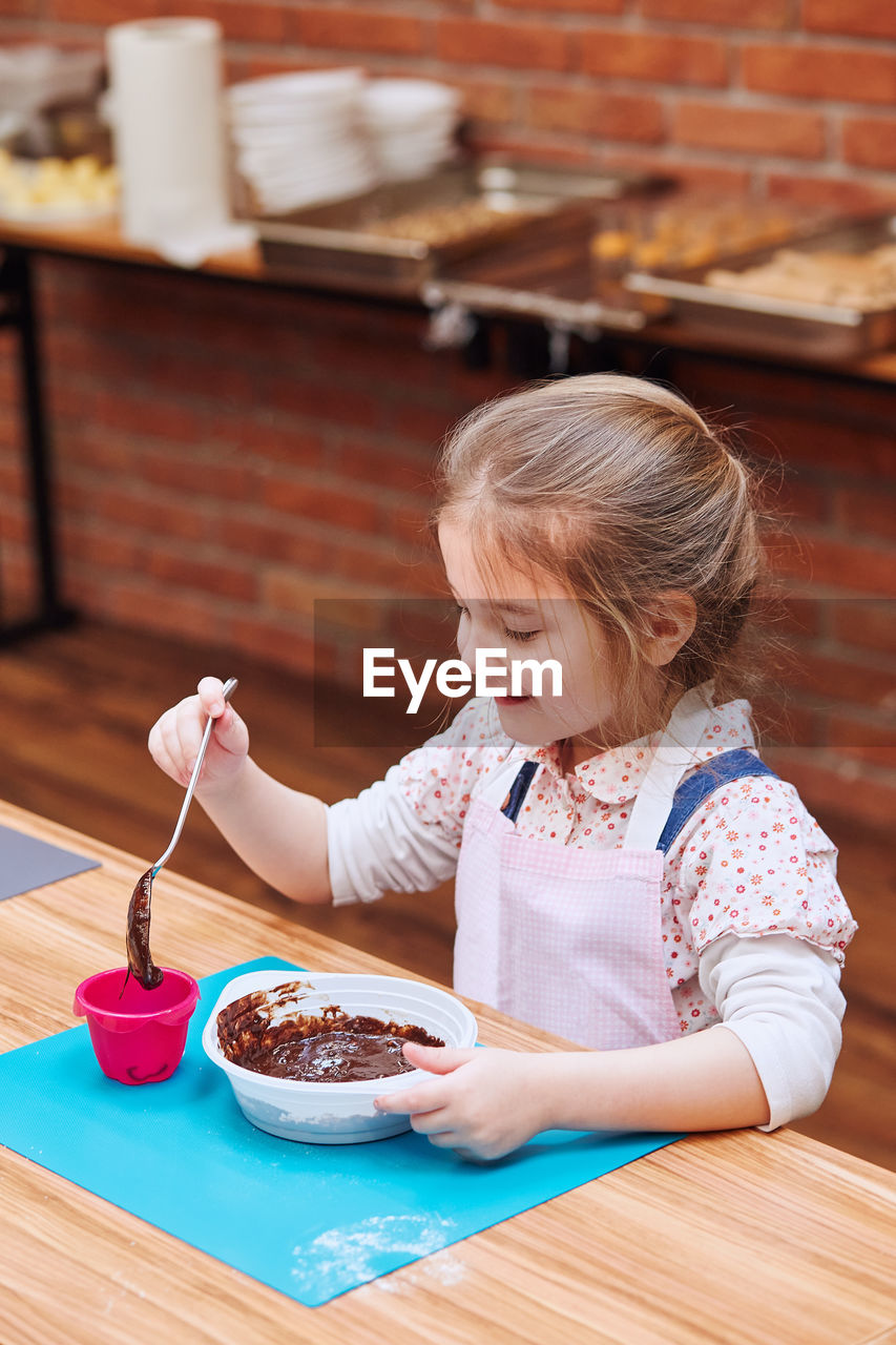 Girl making cake in classroom