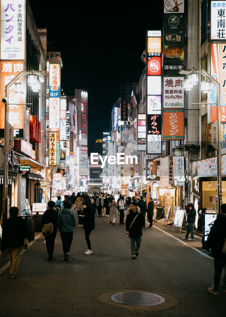 People walking on street at night.