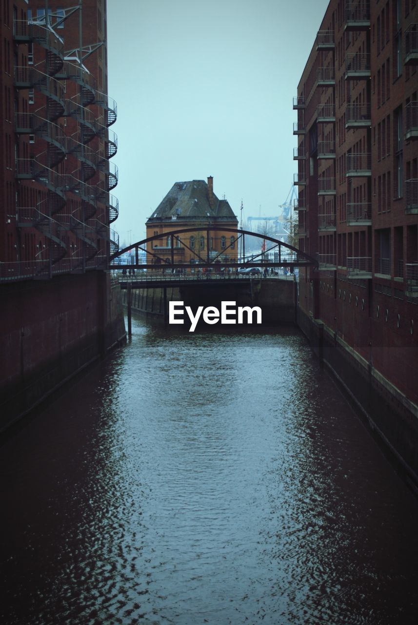 Bridge over river by buildings in city