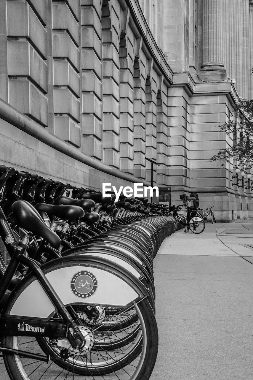 BICYCLE PARKED ON STREET AGAINST BUILDING