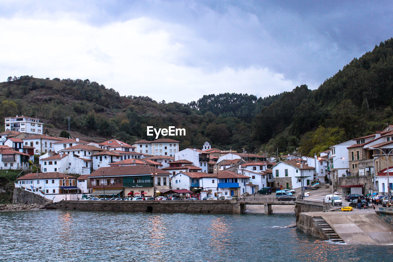 VIEW OF TOWNSCAPE WITH RIVER IN FOREGROUND