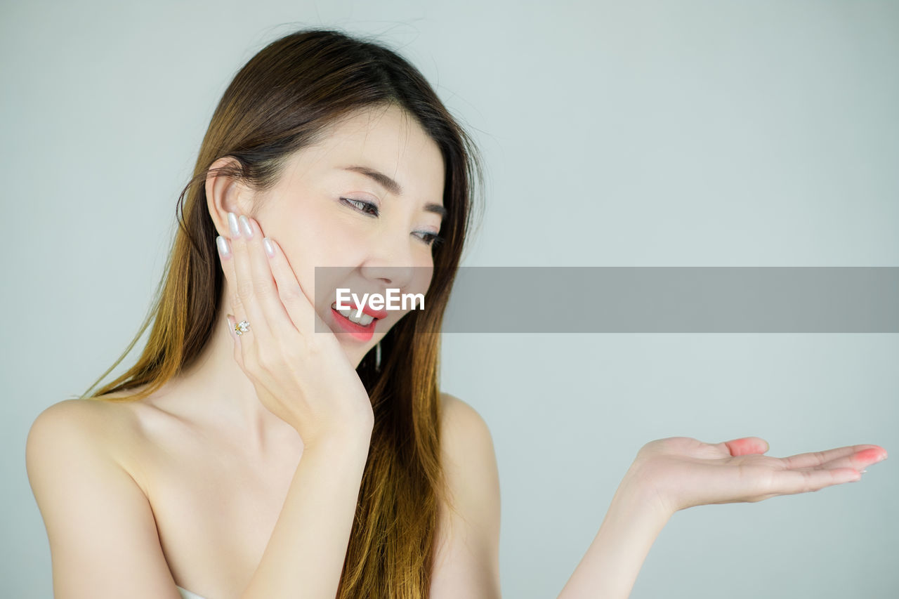 Woman gesturing against white background