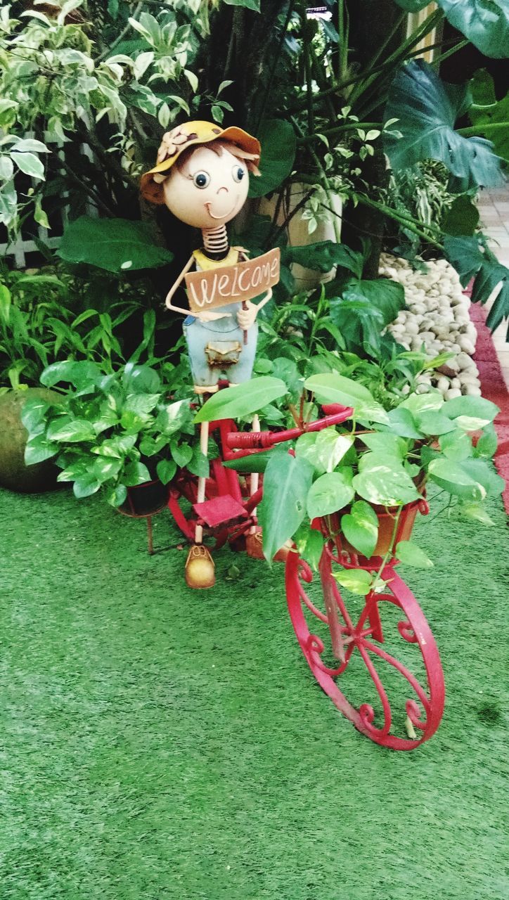 CLOSE-UP OF FEMALE STATUE WITH PLANTS