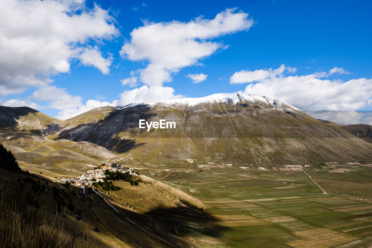 Scenic view of landscape and mountains against sky in castelluccio, umbria italy